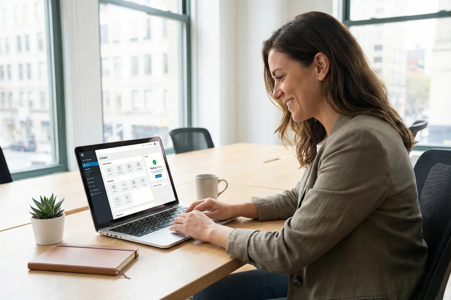 A woman sits at a modern desk in a bright office, smiling while looking at her laptop. It shows an organized business website that follows proper website maintenance tips. The office has minimal decor, and the natural light adds warmth to the space.